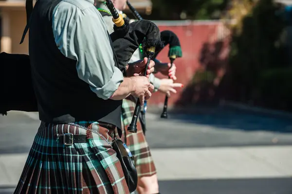Why do bagpipe players walk when they play?